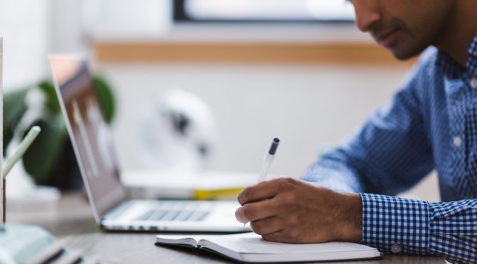 man writing secondary application