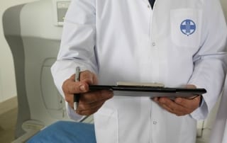 man in lab coat writing medical school admissions application